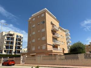 a tall building with a car parked in front of it at Voramar VI in Piles