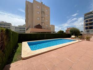 a swimming pool in front of a building at Voramar VI in Piles
