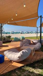 eine Gruppe von Sitzsäcken auf einem Holzdeck mit Blick auf den Strand in der Unterkunft Villa 4 bedrooms, Sedra resort, North coast in Sidi Kirayr