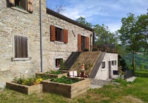 a person standing in front of a stone building at Agriturismo Coradosso "La casetta" in Selvapiana