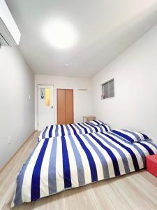 大阪市にある天下茶屋の大きな青と白の縞模様のベッドがある寝室