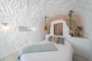 a bedroom with a bed in a white wall at Complejo Cuevas Otto in Baza