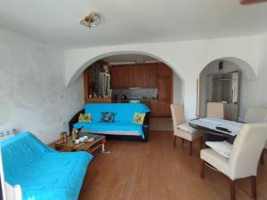 a living room with a blue couch and a table at Amarillys in Donji Morinj