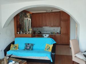 a living room with a blue couch in a kitchen at Amarillys in Donji Morinj