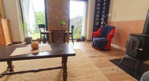 a living room with a table and a wood stove at Ti an Avel, petite maison indépendante avec jardin à 5 minutes à pied de la mer in Plougrescant