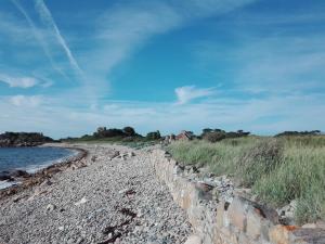 a rocky beach next to a body of water at Ti an Avel, petite maison indépendante avec jardin à 5 minutes à pied de la mer in Plougrescant