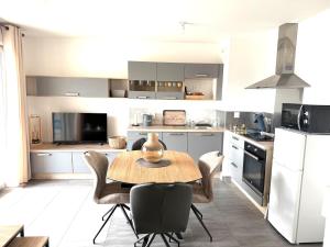 a kitchen with a table and chairs in it at Appartement T2 Cosy in Villette-dʼAnthon