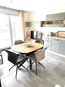 a kitchen and dining room with a table and chairs at Appartement T2 Cosy in Villette-dʼAnthon +5 photos