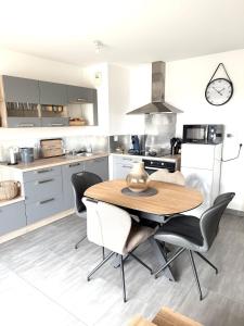 a kitchen with a wooden table and chairs at Appartement T2 Cosy in Villette-dʼAnthon