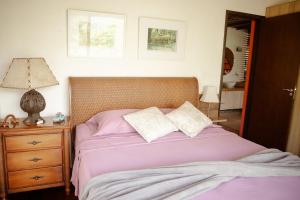 a bedroom with a bed with purple sheets and a lamp at Refúgio paradisíaco em frente a Serra da Bocaina ! in São José do Barreiro