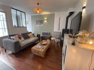 a living room with a couch and a table at La maison de la Sauzaie in La Flotte