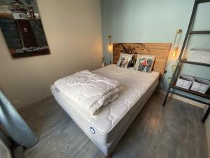 a bedroom with a bed with white sheets on it at La maison de la Sauzaie in La Flotte
