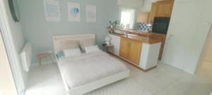 a small bedroom with a bed and a kitchen at Studio Matisse in Theix