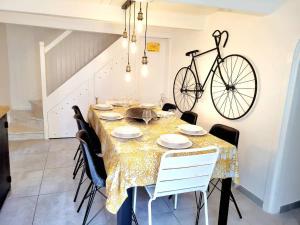 a dining room with a table with a bike on the wall at La Maison du Puits Fleuri in Ars-en-Ré