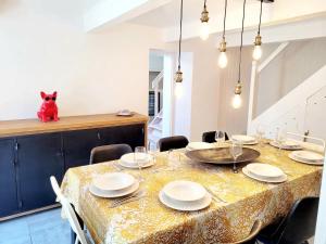 a dining room with a table and a cat sitting on a counter at La Maison du Puits Fleuri in Ars-en-Ré +10 photos