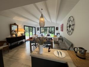 Una sala de estar con una mesa y un comedor. en La Villa des Peupliers, en Les Portes