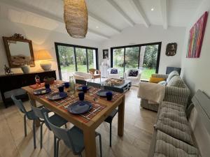 Una sala de estar con una mesa y sillas de madera. en La Villa des Peupliers, en Les Portes 12 fotos más
