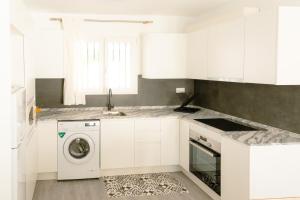 a white kitchen with a washing machine in it at Adosado Las Piñas Primestay in Benicarló