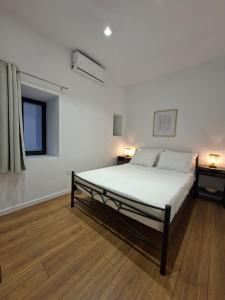 a white bedroom with a bed in a room at Beautiful Plomari Cottage in Plomari