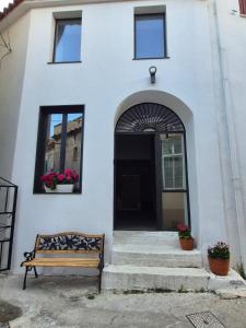 a building with a bench in front of a door at Beautiful Plomari Cottage in Plomari