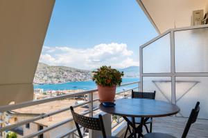 a table with a potted plant on top of a balcony at Mariana Apartments in Sarandë +180 photos
