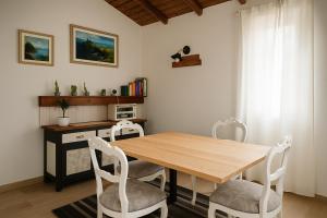a dining room with a wooden table and white chairs at B&B Il Fiore nel Bosco in Orte