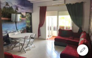 a living room with a table and a red couch at Beralmar Asilah New in Asilah