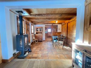 ein Wohnzimmer mit einem Holzofen und einem Tisch in der Unterkunft Chalet montagnard chaleureux avec poêle, terrasse et animaux acceptés - FR-1-505-154 in Notre-Dame-de-Bellecombe