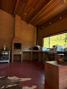 a large room with a kitchen with a large oven at La Maison De Bonneval in São Bento do Sapucaí