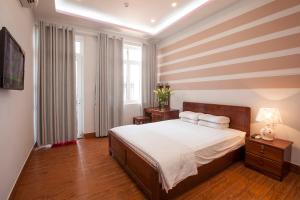 a bedroom with a bed with a striped wall at Phuong Nam Guest House in Mui Ne