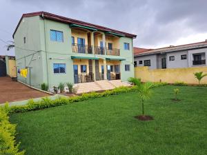 a house with a green lawn in front of it at Résidence TIFI in Yaoundé