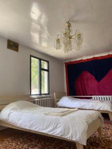 a bedroom with two beds and a chandelier at Nooruz hotel in Naryn