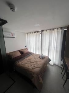 un letto in una camera da letto con una grande finestra di Get by Side Suites a Tambaú Altre 15 foto