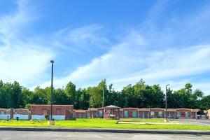 un parcheggio vuoto con un gruppo di edifici di OYO Hickory House Inn a Dexter