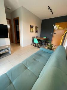 a living room with a blue couch and a table at Edíficio Sienna in Ribeirão Preto