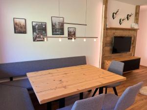 a dining room with a wooden table and chairs at Bergtraum Aparthotel in Mittelberg