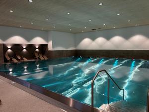 a lap pool in a hotel room with blue water at Bergtraum Aparthotel in Mittelberg