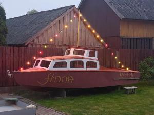 een boot ligt geparkeerd voor een schuur bij Ģimenes studija 2 in Pāvilosta +3 foto's