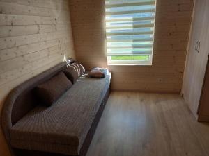 een grote bank in een kamer met een raam bij Ģimenes studija 2 in Pāvilosta