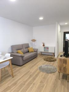 a living room with a couch and a table at Siralvar vivienda turística Arís in Cabana de Bergantiños