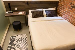two beds in a room with a brick wall at Mixx Hotel in Petaling Jaya