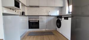 a kitchen with white cabinets and a washer and dryer at Casa Praia Norte II - PVZ in Póvoa de Varzim +31 photos