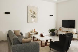 a living room with a couch and a table and a tv at Casa Luna - Villa Mango in Pointe-Noire