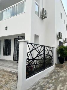 a white building with black windows and a courtyard at Casa Luna - Villa Mango in Pointe-Noire