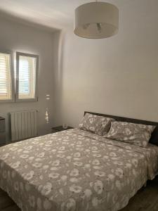 a bedroom with a bed with a floral bedspread at Tenuta Sillo Primo Piano in Uggiano Montefusco