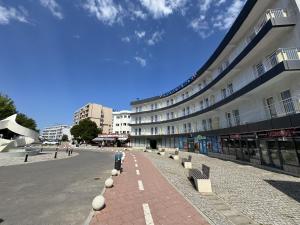 a building with a brick sidewalk next to a street at Hotel Golden Beach in Eforie Nord