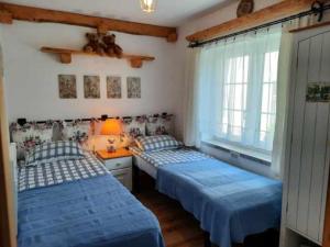 a bedroom with two beds and a table with a lamp at Agroturystyka Kaczeniec in Ustronie Morskie