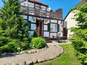 a house with a deck on top of it at Agroturystyka Kaczeniec in Ustronie Morskie