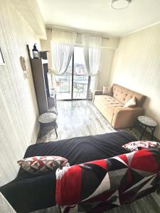 een woonkamer met een bed en een bank bij Dpto acogedor con terraza privada in Lima
