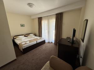 a hotel room with two beds and a television at Hotel Golden Beach in Eforie Nord